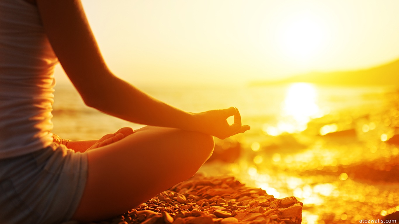 hand of a woman meditating in a yoga pose on the beach